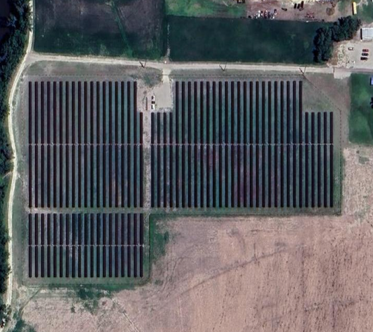 A large solar farm with rows of solar panels on a clear day.