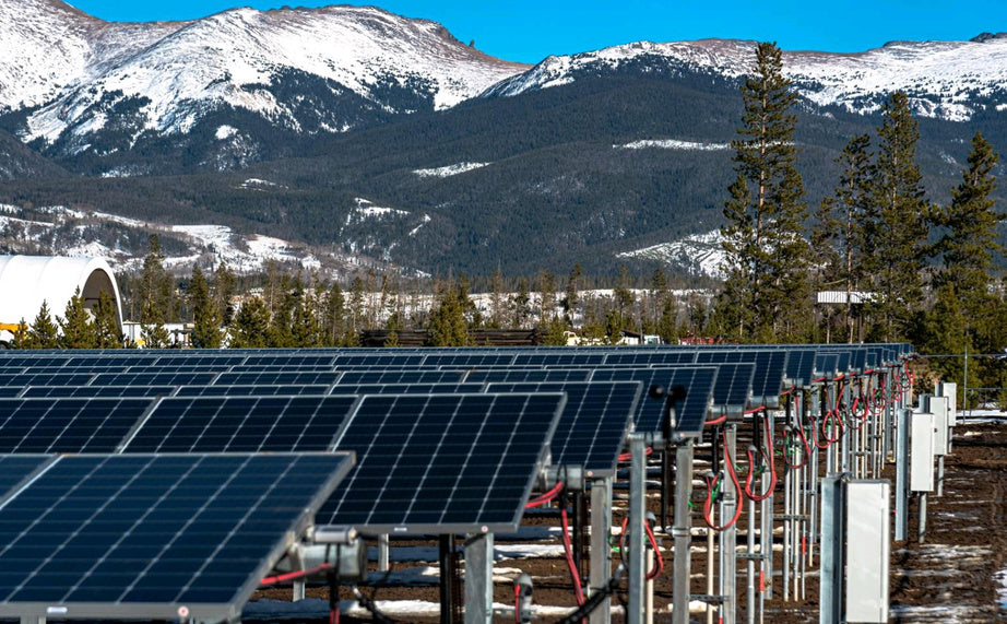 Solar panels in an array with mountains in the background