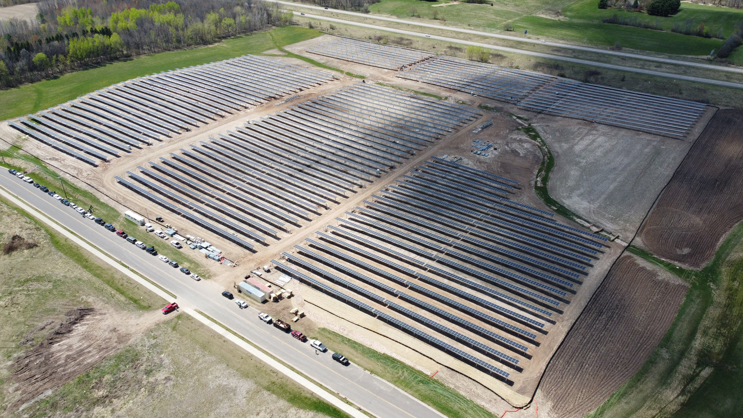 Aerial view of a large solar farm with rows of solar panels.
