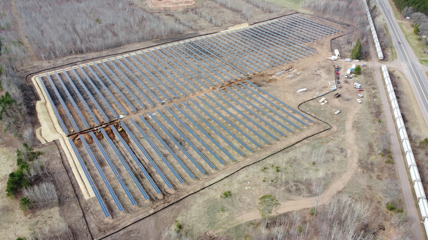 Aerial view of a solar farm with rows of solar panels on a clear day.